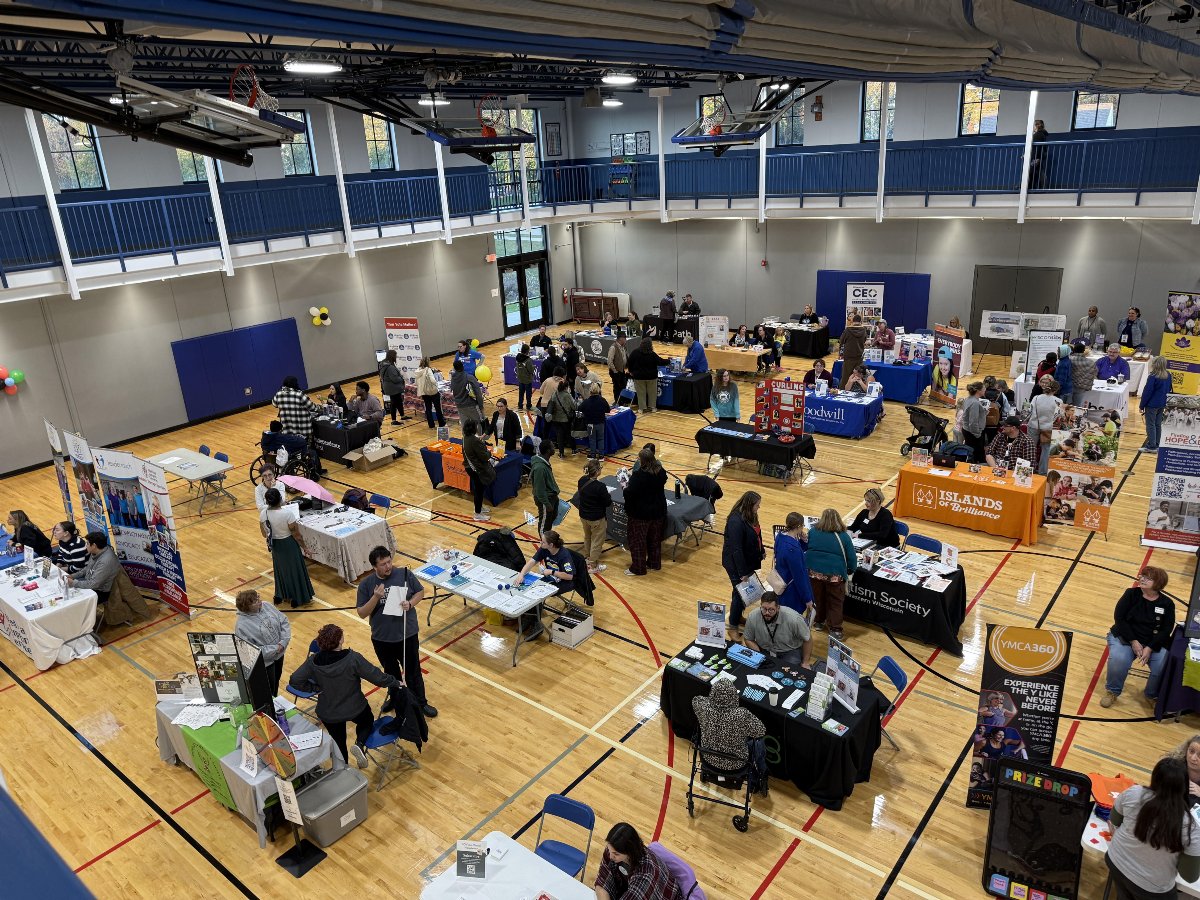 tables in a gym with wood floor for a resource fair